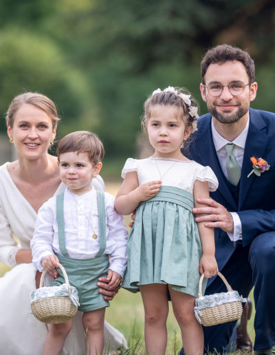 Couple de jeunes mariés avec leurs enfants d'honneur en vert sauge