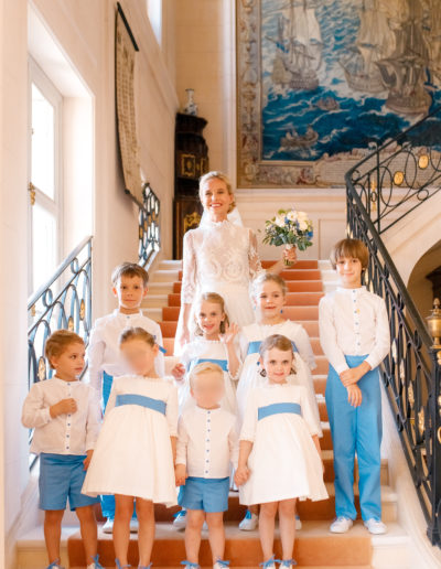 Enfants d'honneur en bleu et blanc entourant la mariée