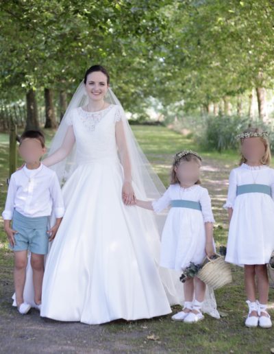 Enfants d'honneur en lin blanc et vert entourant la mariée